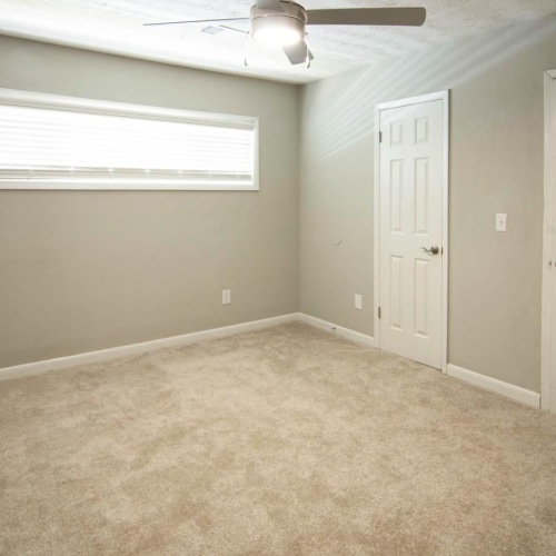a room with a ceiling fan and a door